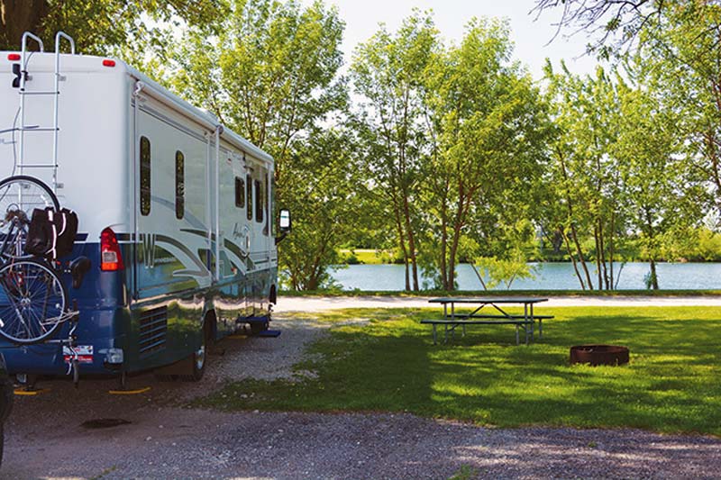 RV parked overlooking lake nice shaded spot, with picnic table and firepit.
