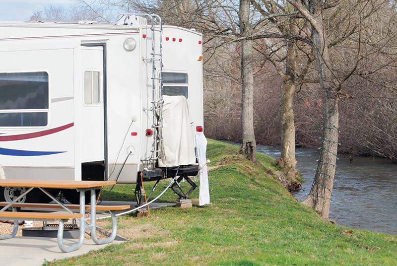 RV travel trailer near stream