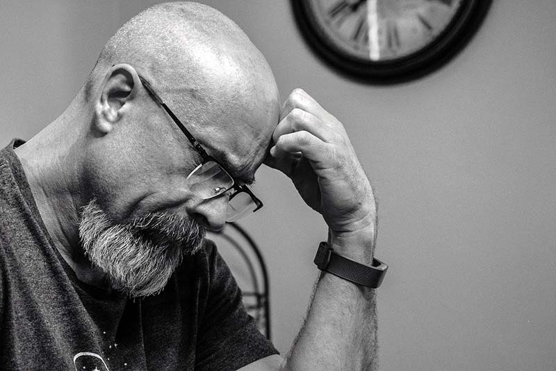 Man looking down, deep in thought while waiting to hear back from a Workamper employer.