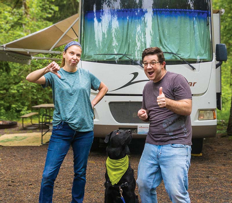 Workamping couple Levi and Natalie Henley showing thumbs up and thumbs down gestures with their dog by an RV, highlighting positive and negative attitudes for Workampers.