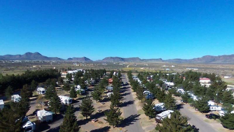 Overhead view of Lost Alaskan RV Park showing organized RV sites and wooded areas, highlighting the campground layout for Workampers.