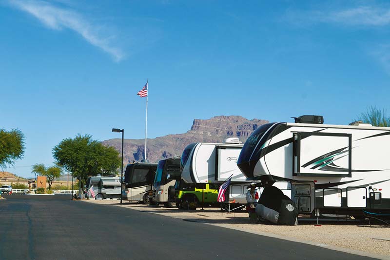 Line of RVs at Cal-Am Resort with the Superstition Mountains in the background, showcasing a popular destination for Workampers in Arizona.