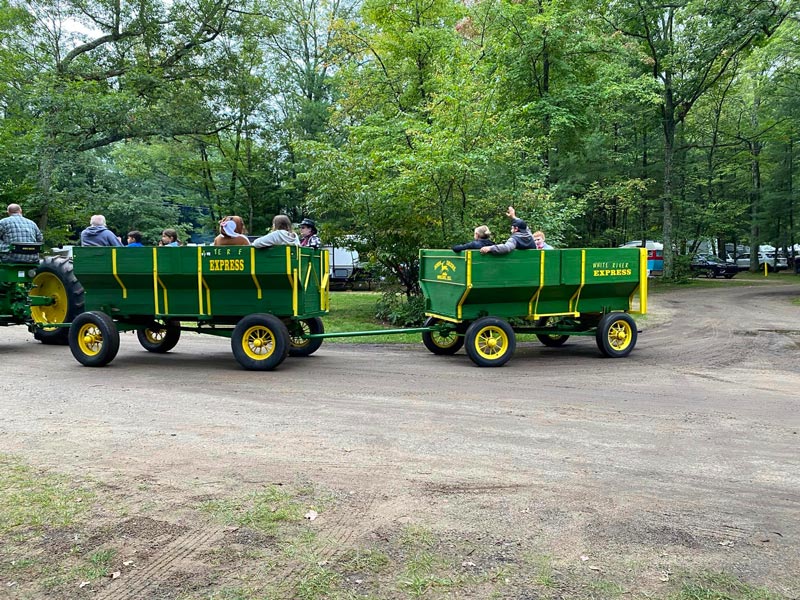 white river rv park guests enjoy a tour of the campground in wagons hauled for an old john deer tractor