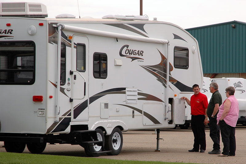rv sales person showing fifth-wheel to customers