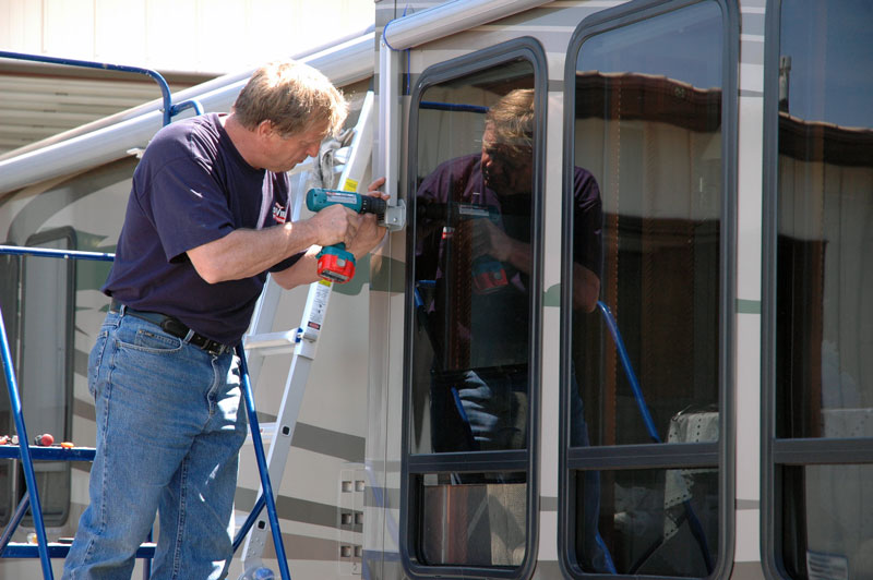 rv service repair tech installing awning