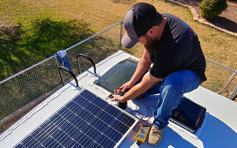 justin mowery installs a solar panel on an rv roof