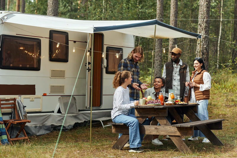 diverse group of rv campers around a picnic table