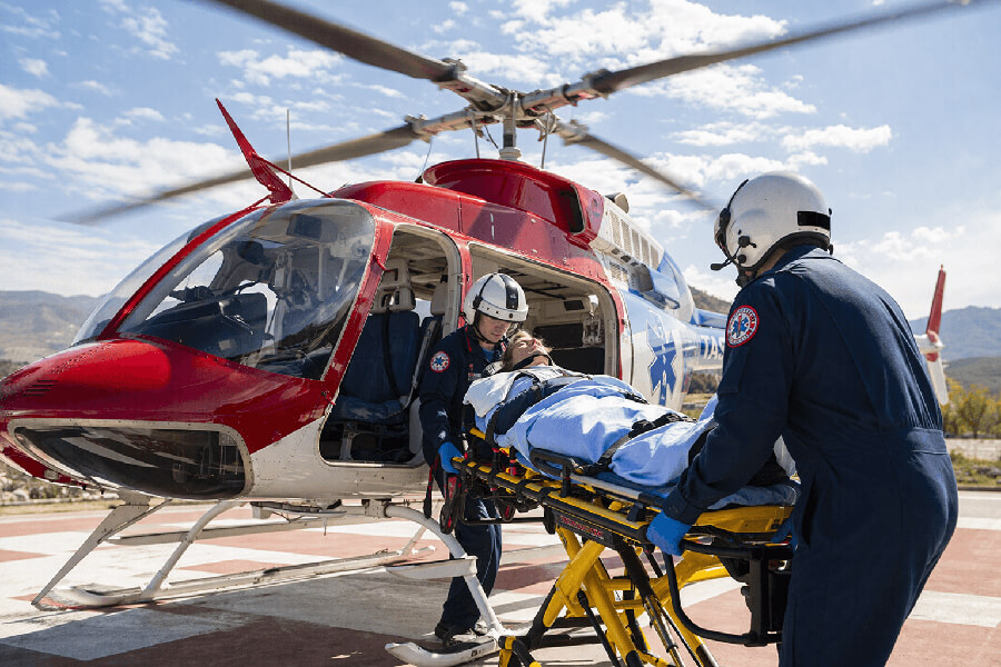 unloading a patient on a stretcher from helicopter medevac on a sunny day