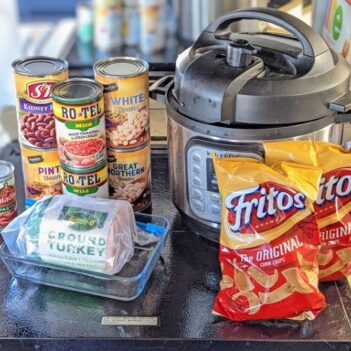 Instapot sitting on RV stovetop with all the ingredients needed to make Frito pies.