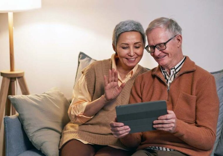Two people on a couch using a tablet to research or practice for a Workamper job interview, illustrating preparation tips for success.