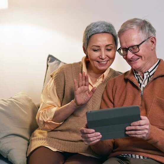 Two people on a couch using a tablet to research or practice for a Workamper job interview, illustrating preparation tips for success.