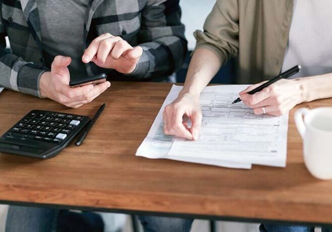 Workamping couple completing taxes at home, organizing documents and forms on a table.