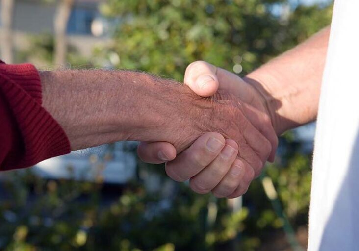 Workamper and employer shaking hands, illustrating agreement or partnership.