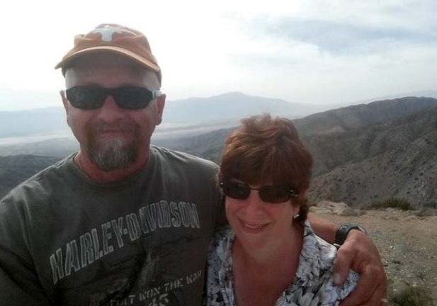 Workamper couple the Youngs smiling for a selfie on a scenic hilltop in South Dakota’s Black Hills.
