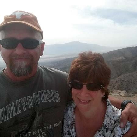 Workamper couple the Youngs smiling for a selfie on a scenic hilltop in South Dakota’s Black Hills.