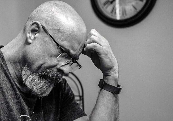 Man looking down, deep in thought while waiting to hear back from a Workamper employer.