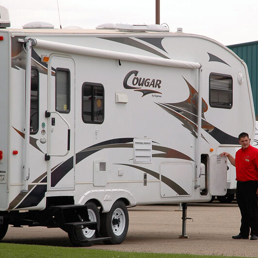 rv sales person showing fifth-wheel to customers