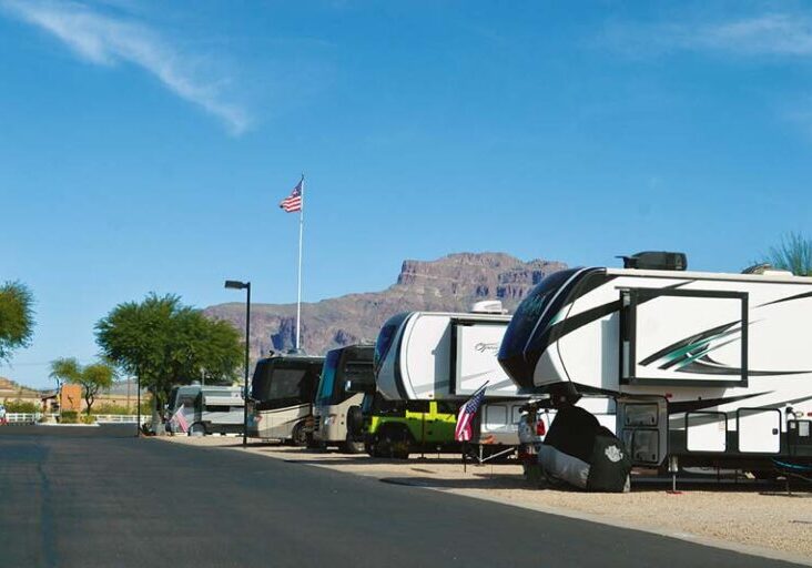 Line of RVs at Cal-Am Resort with the Superstition Mountains in the background, showcasing a popular destination for Workampers in Arizona.
