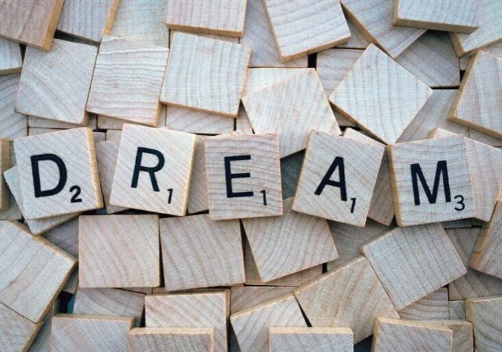 Scrabble tiles spelling out the word Dream, on top of upside down tiles.