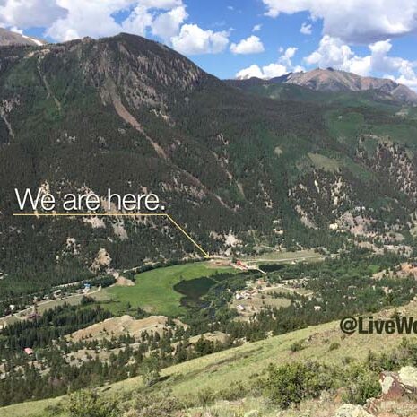 View of a ranch in a valley below mountains