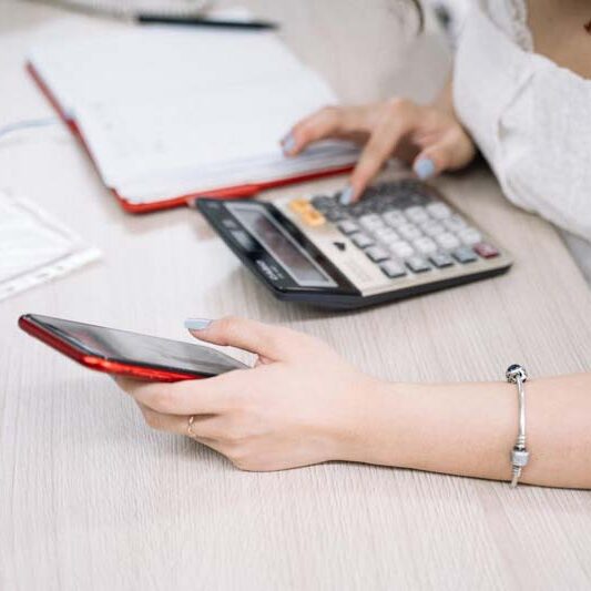 Person using calculator and phone doing the math on a Workamping job.